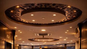 A hotel lobby with a polished floor, a circular ceiling design, and a view of the outside through glass doors. - Panorama Amman Hotel (Amman)