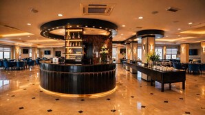 A spacious lobby with a central bar area, seating arrangements, and a polished floor. - Panorama Amman Hotel (Amman)