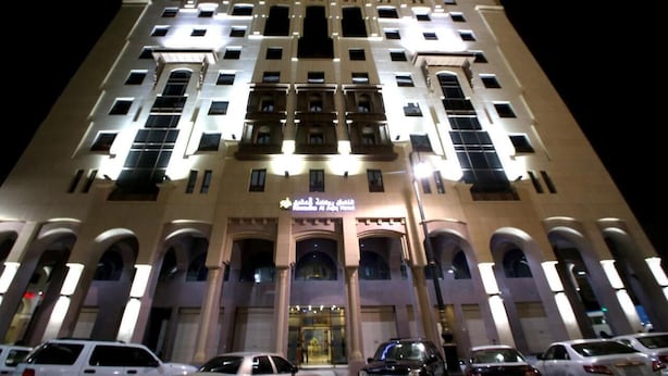 Un edificio de varios pisos con fachada simétrica, ventanas amplias y una entrada central.