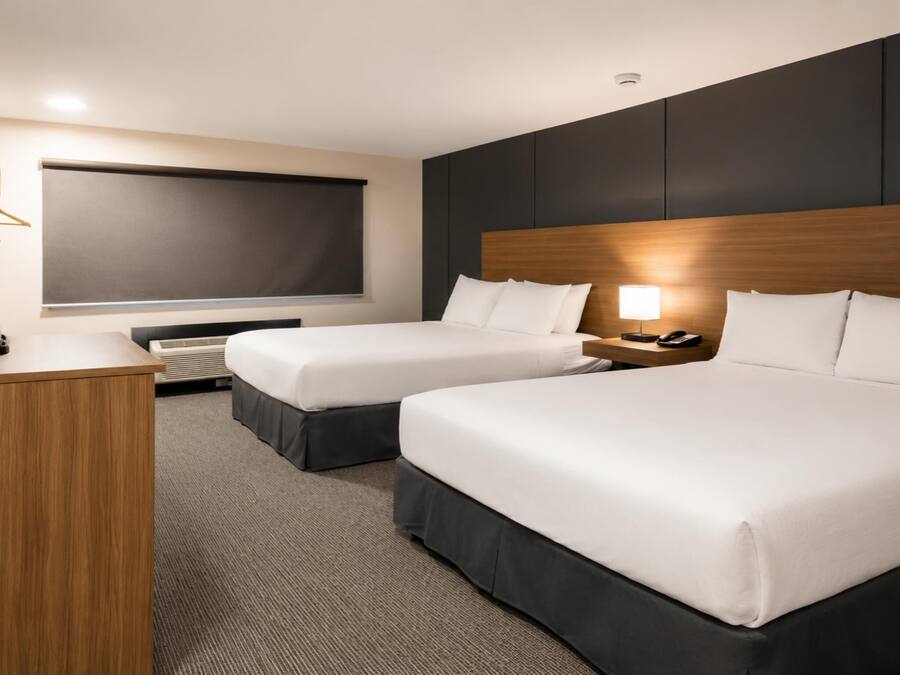 Une chambre d’hôtel avec deux lits, un bureau, un téléviseur à écran plat et une lampe de chevet.