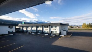 A hotel with a parking lot and a mountain view. - SureStay by Best Western Smithers (Smithers)