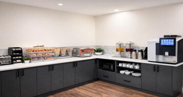 Cocina moderna con espacio para café, tostadora, microondas y alacenas.