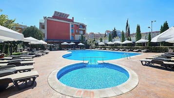 Una piscina al aire libre de temporada, sillones reclinables de piscina