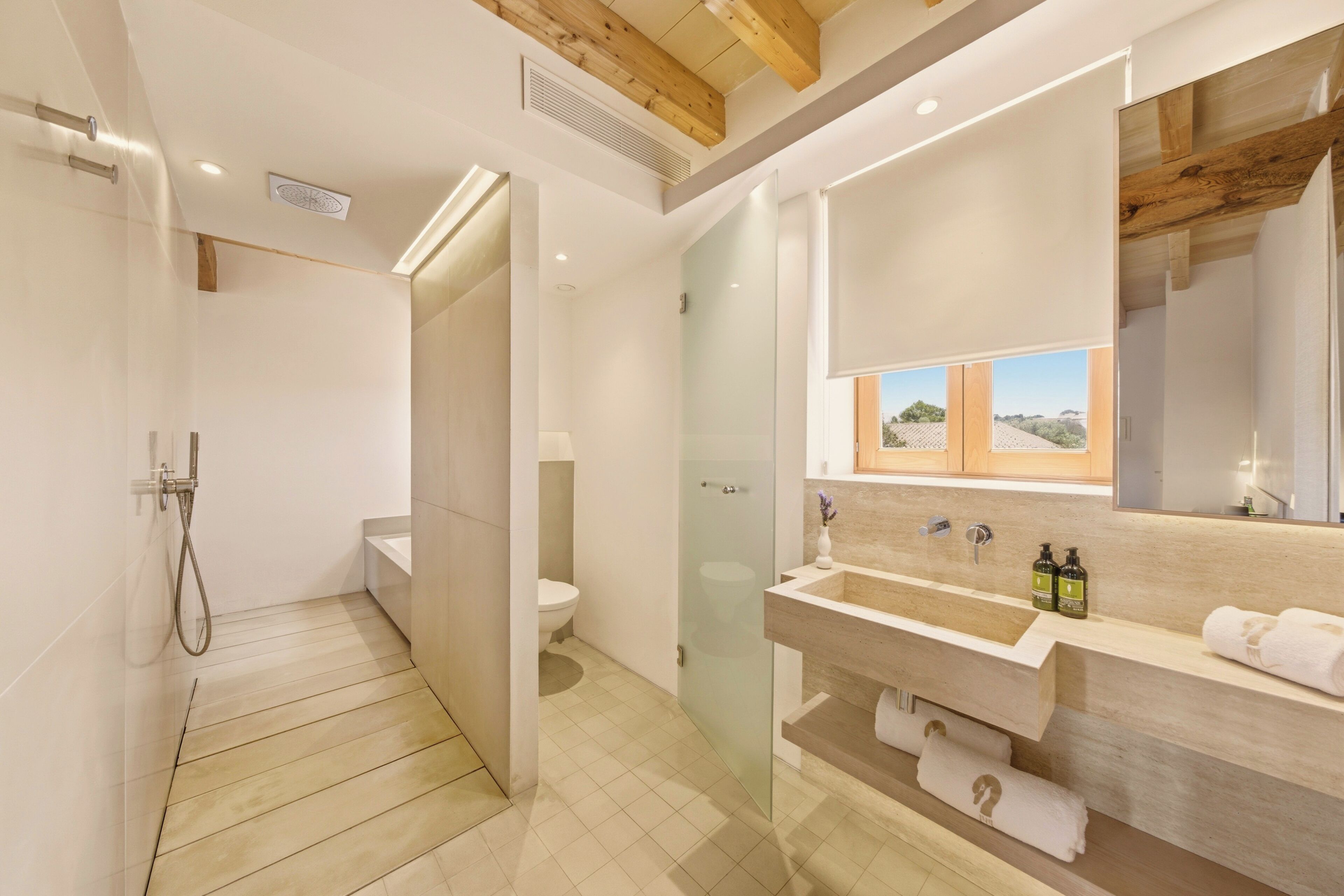 Une salle de bain moderne avec une douche à parois de verre, un meuble-lavabo en bois et un grand miroir.