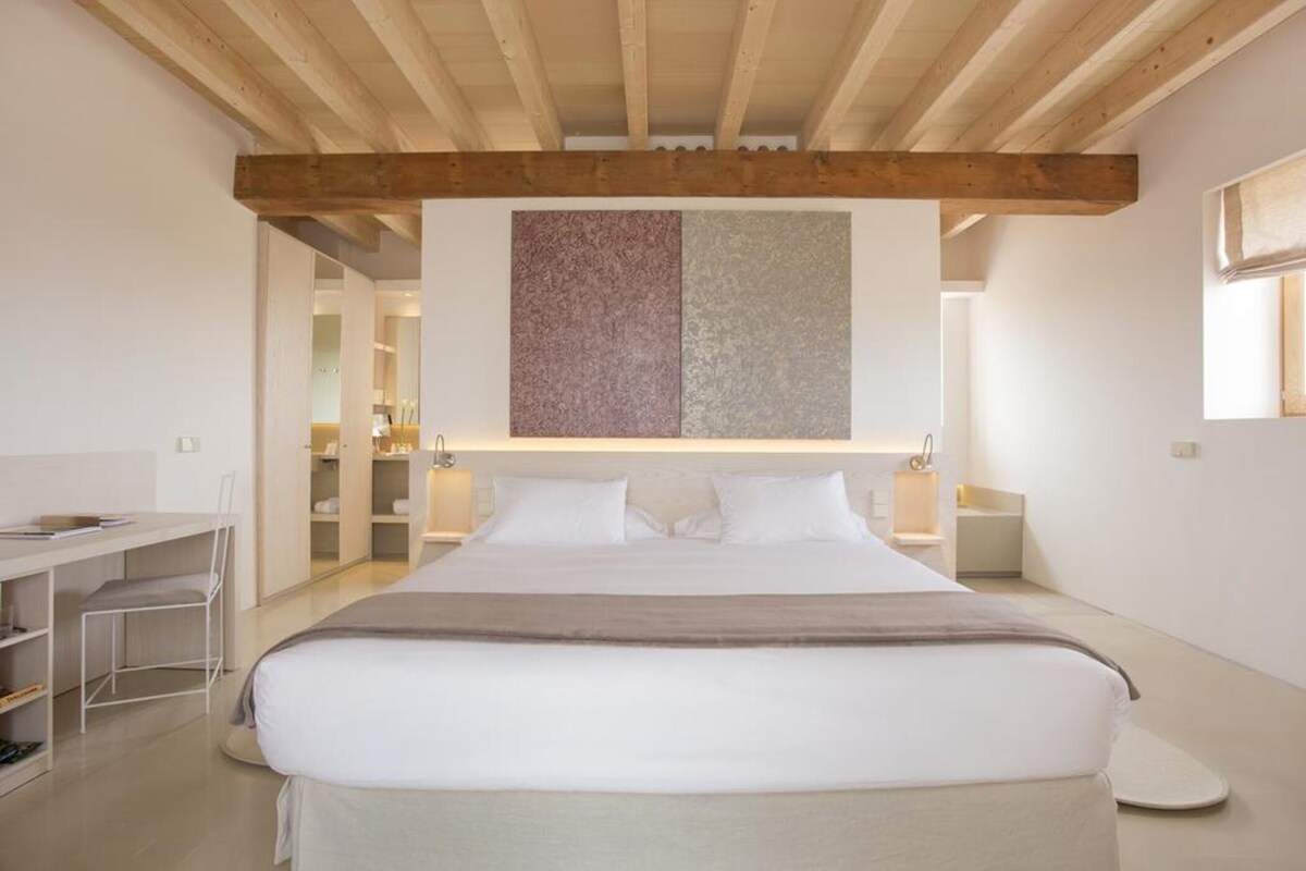 Une chambre à coucher moderne avec un grand lit, un bureau et une armoire.
