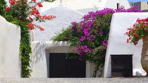 Un bâtiment aux murs blancs, doté d’une porte noire et d’une petite fenêtre.