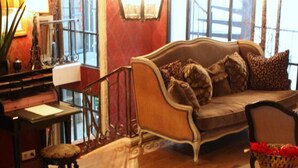 Un salón acogedor con sofá, sillón y piano.