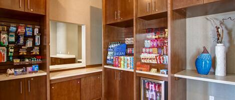 A kitchen with wooden cabinets, a refrigerator, and various food items.