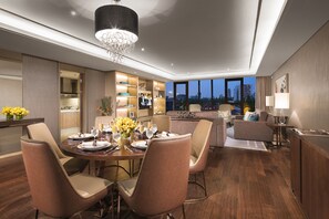 A modern hotel room with a dining area, a sofa, and a view of the cityscape. - Ascott Heng Shan Shanghai (Shanghai)