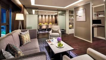 A modern living room with a sofa, armchairs, a coffee table, and a dining area with a table and chairs.