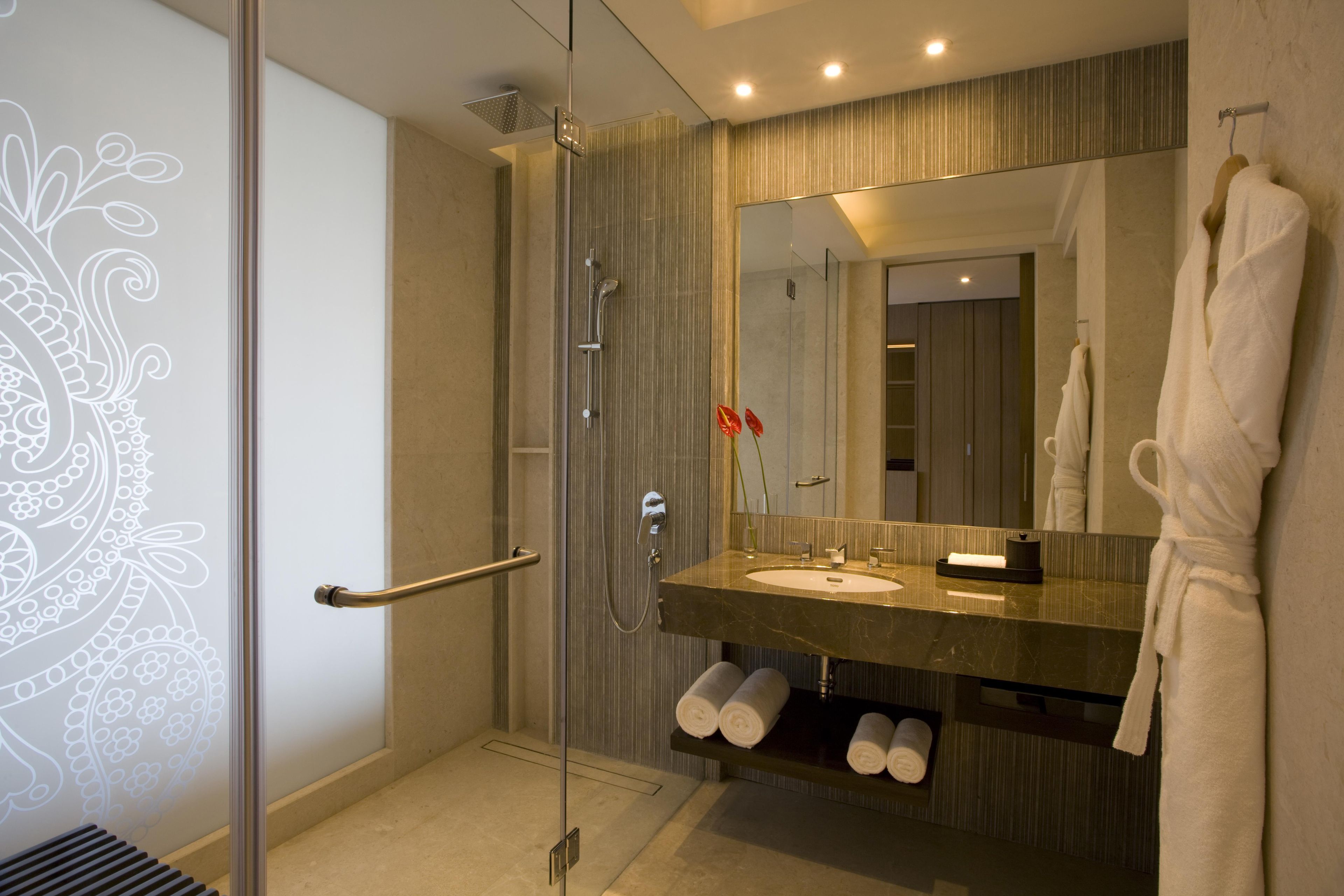 Une salle de bain moderne avec une douche à parois de verre, un meuble-lavabo et un grand miroir.