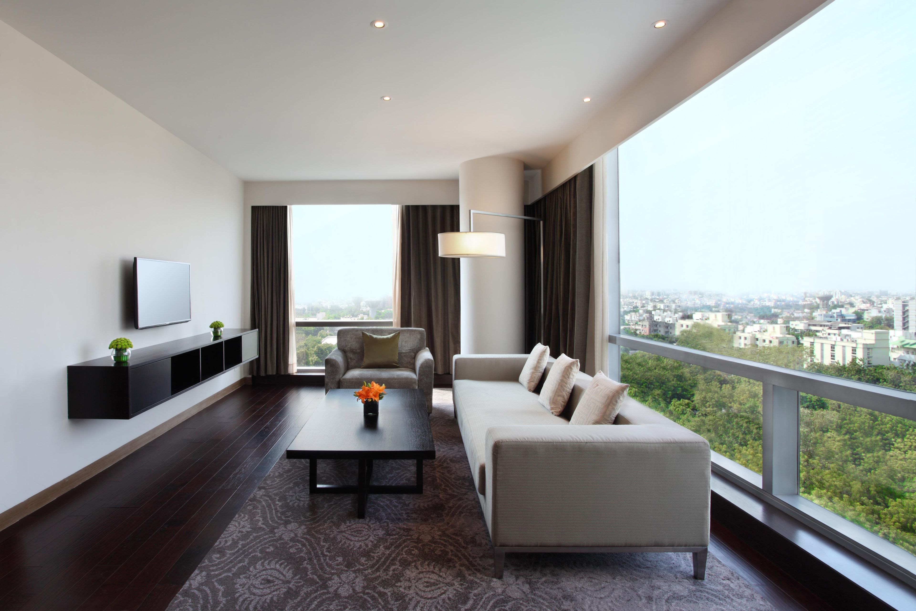 A modern living room with a sofa, a coffee table, and a TV on a wall.