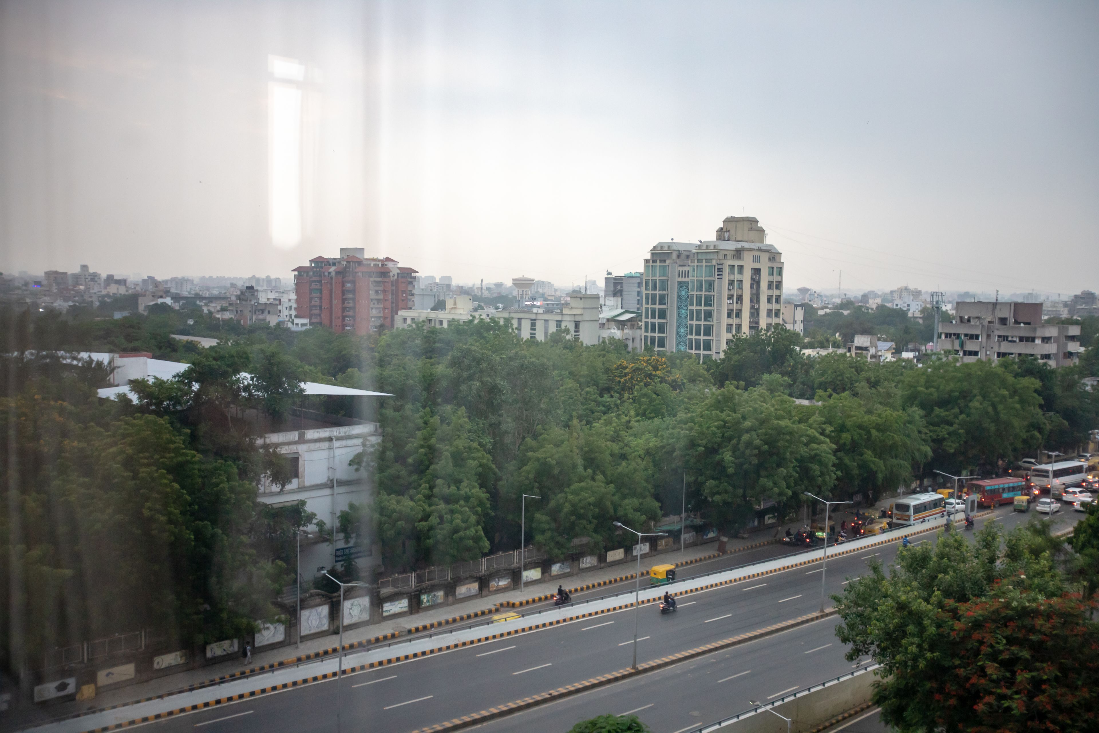 A cityscape with a wide road, buildings, and trees.