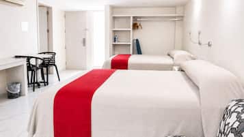 Habitación de hotel con dos camas, un escritorio, sillas y un armario.