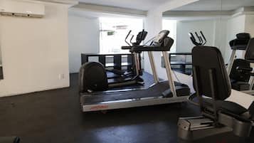 A gym with a treadmill, elliptical, and stationary bikes.