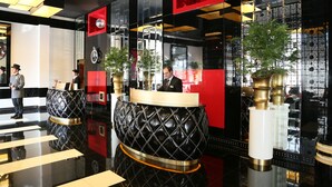 Un moderno vestíbulo de hotel con una decoración en rojo y negro, una recepción y un suelo pulido.