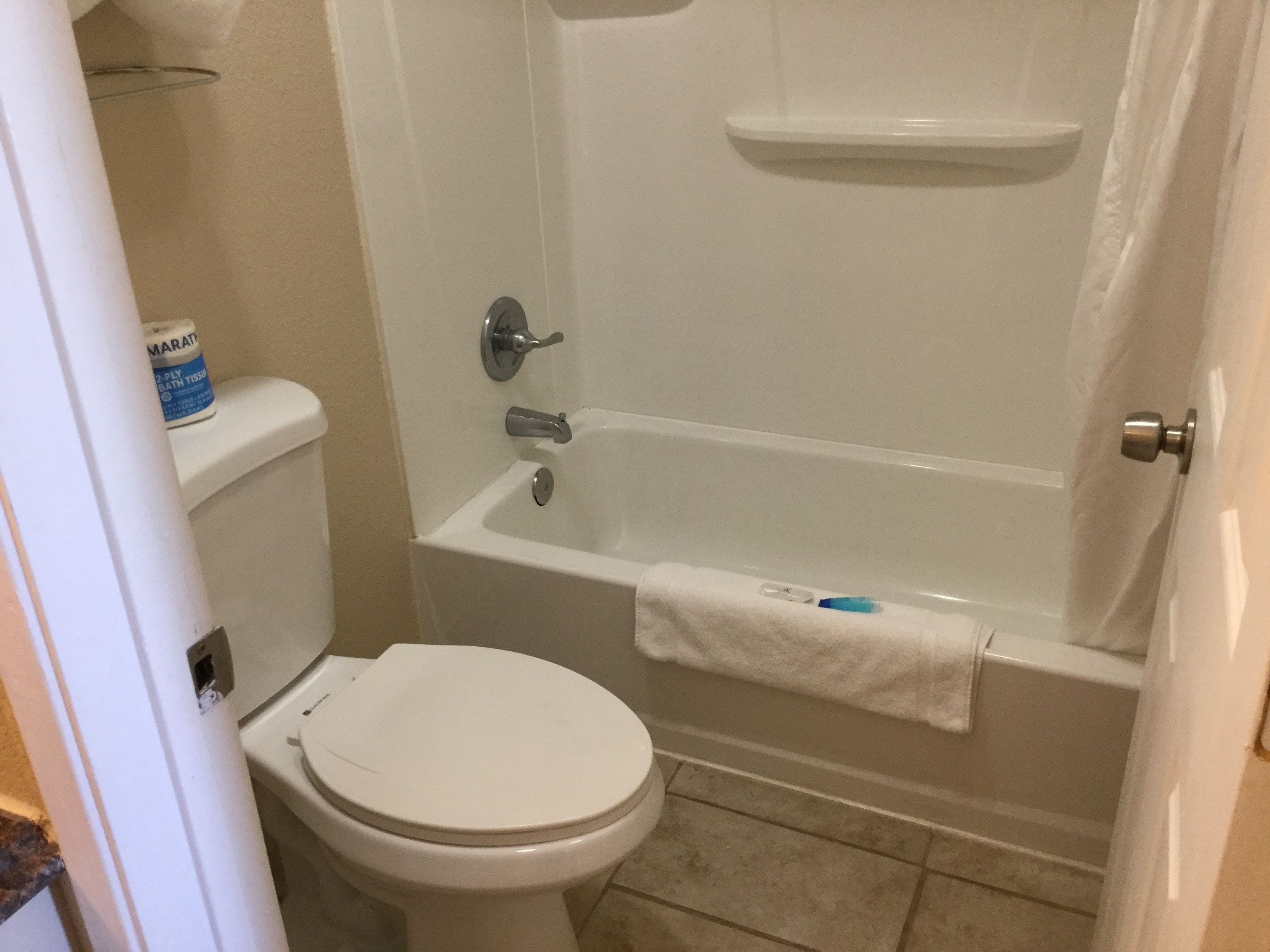 Un baño pequeño y limpio con inodoro, bañera y ducha.