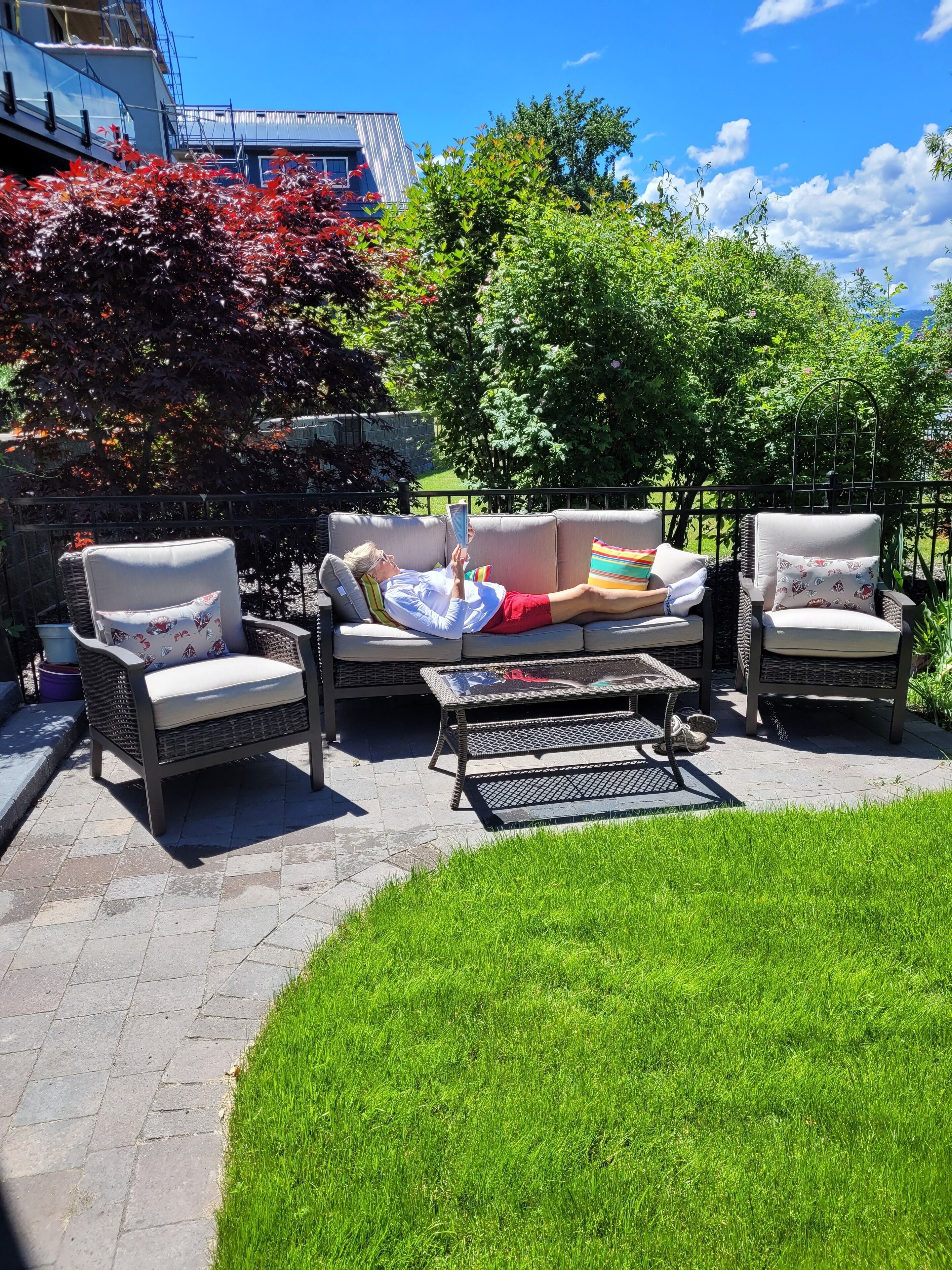 An outdoor patio area with a sofa, two chairs, and a coffee table.