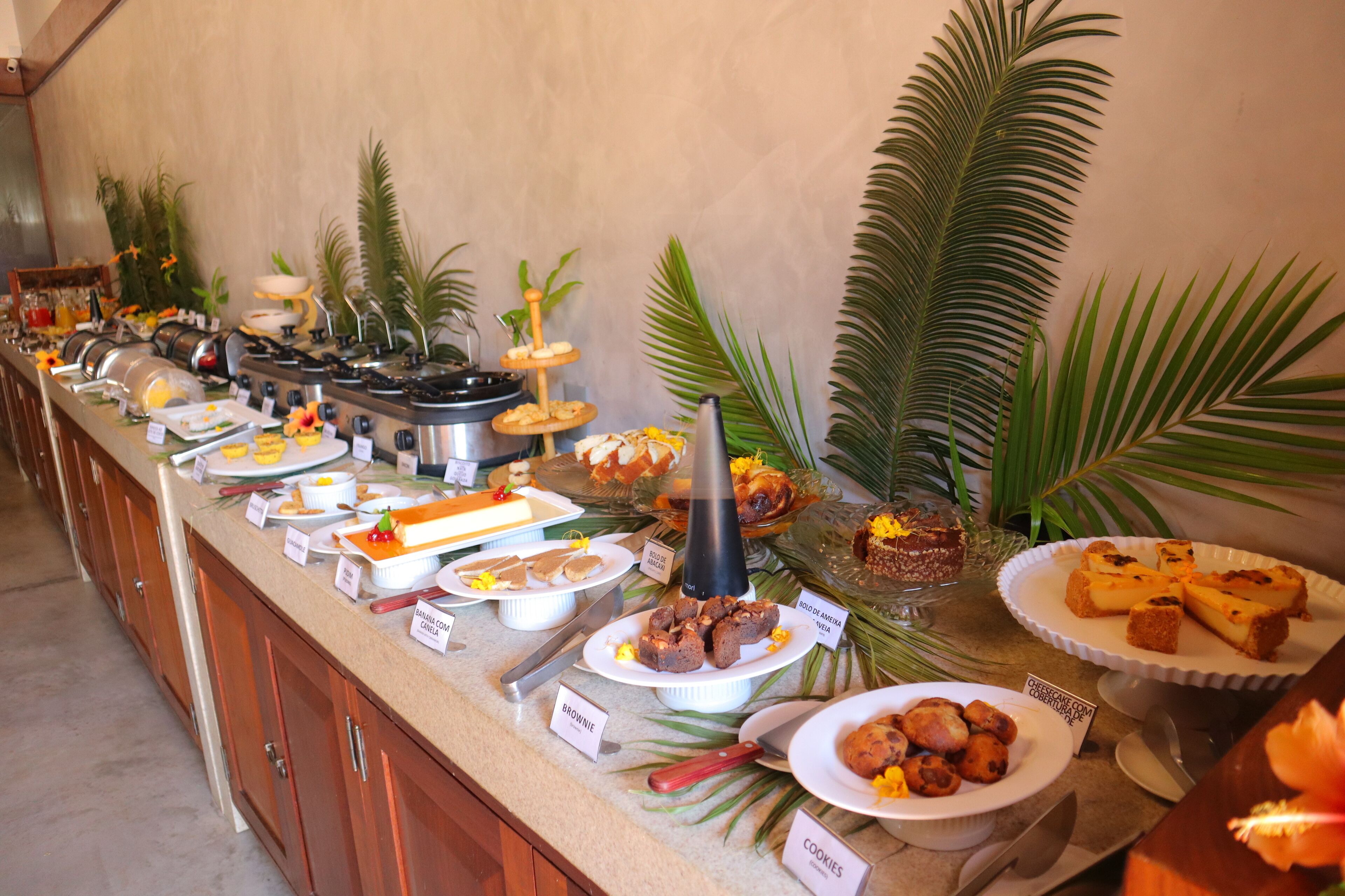 A buffet with various food items, including cakes, cookies, and a coffee station.