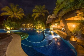 Alberca al aire libre, sombrillas en la alberca y camastros