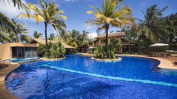 Una piscina al aire libre, sombrillas, sillones reclinables de piscina