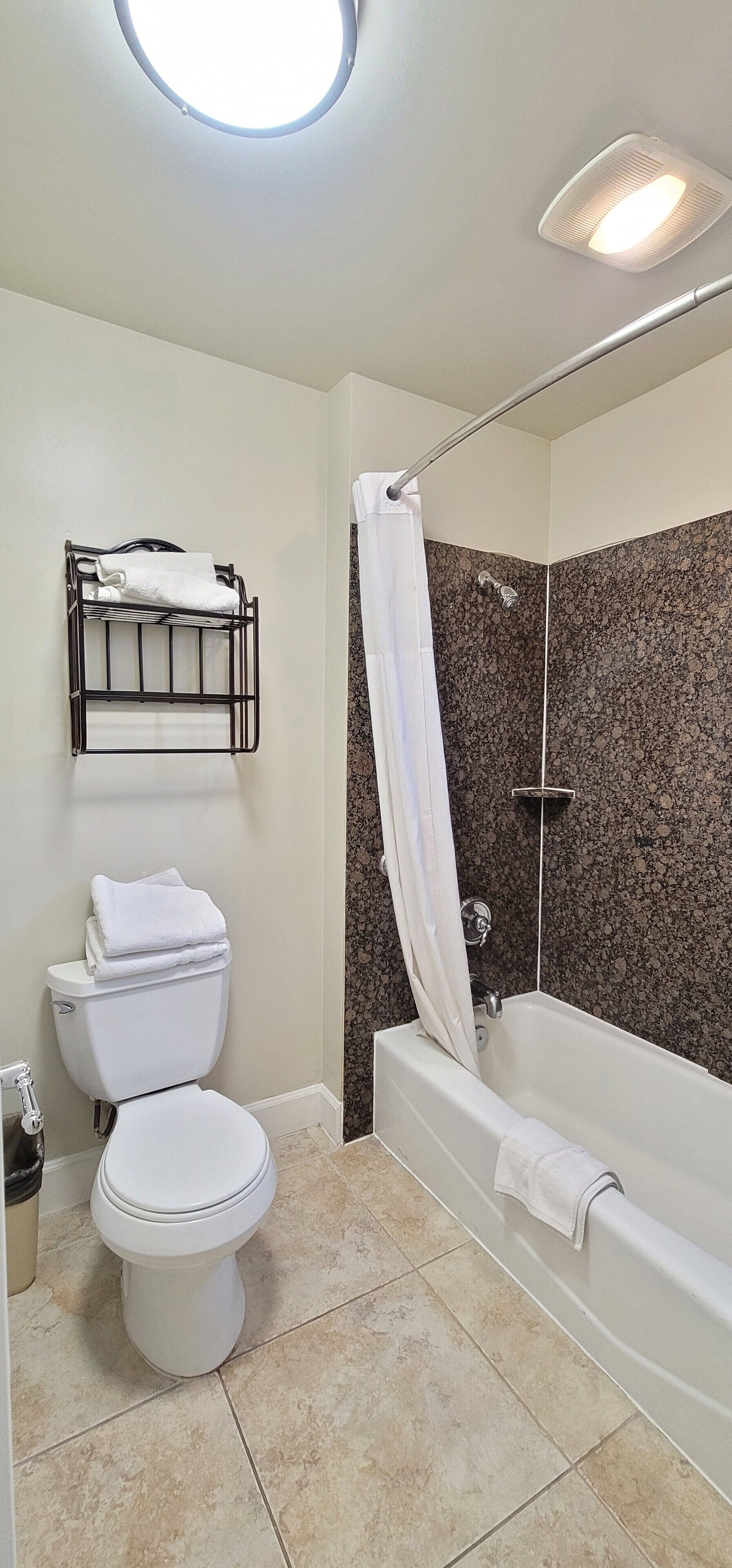 A bathroom with a toilet, a sink, a bathtub, and a shower.