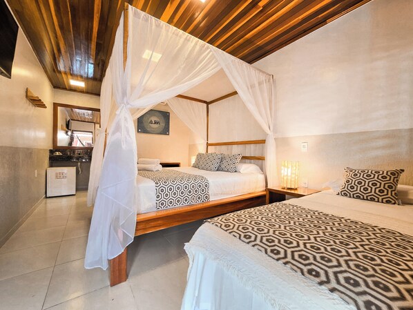 A bedroom with two beds, a wooden ceiling, a small kitchenette, and a mirror. - Rede Andrade Jeri Hotel (Jijoca de Jericoacoara)