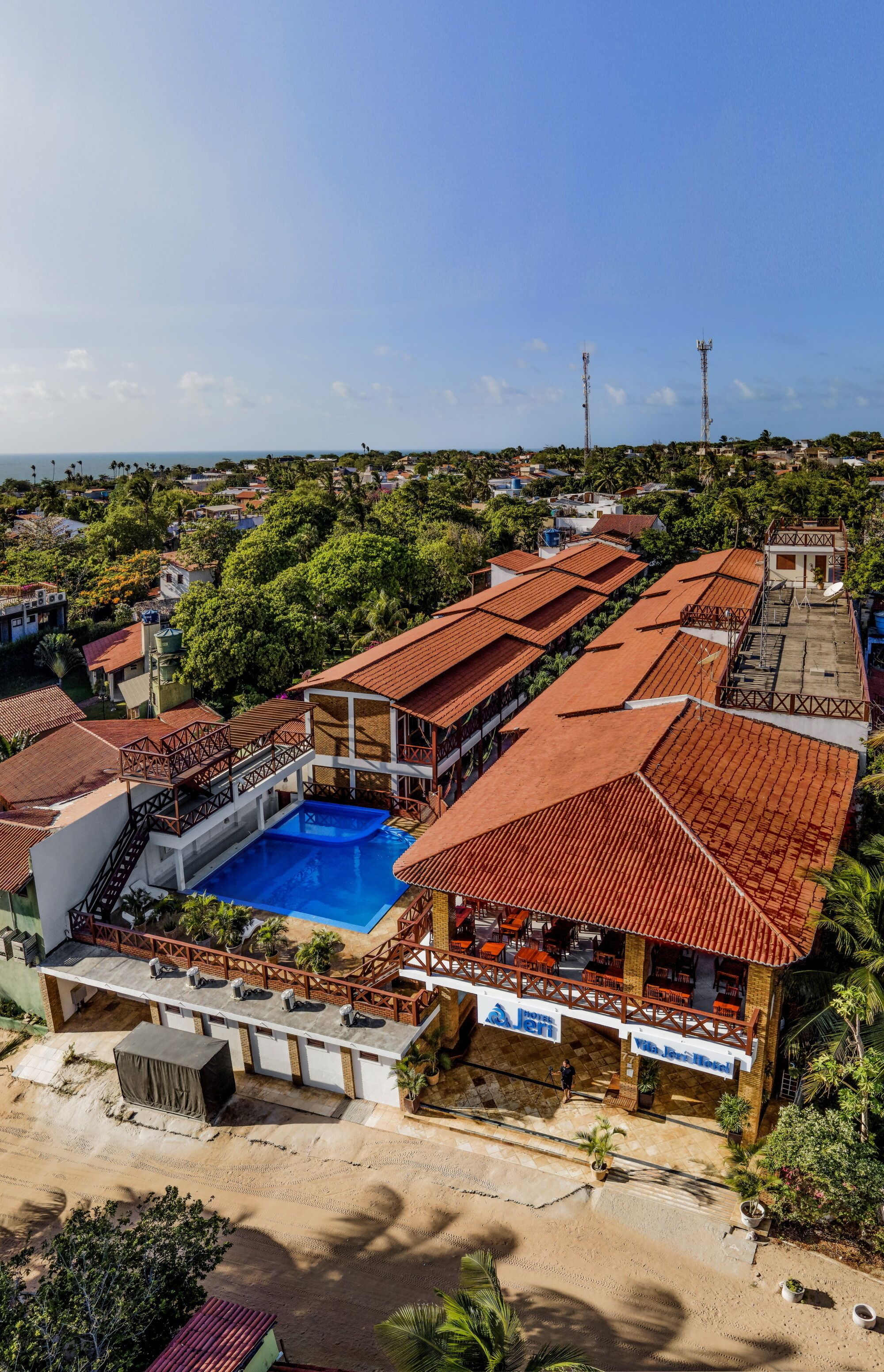 A hotel with a swimming pool, outdoor seating, and a view of the surrounding area.