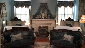 Une chambre à coucher de style traditionnel, avec deux lits, une cheminée et un lustre.