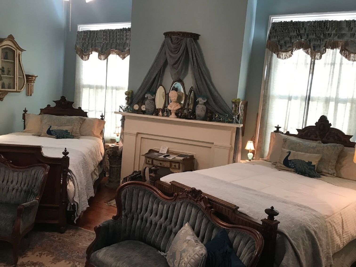 Un dormitorio tradicional con dos camas, una chimenea y decoración de época.
