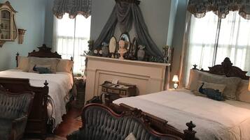Un dormitorio tradicional con dos camas, una chimenea y decoración de época.