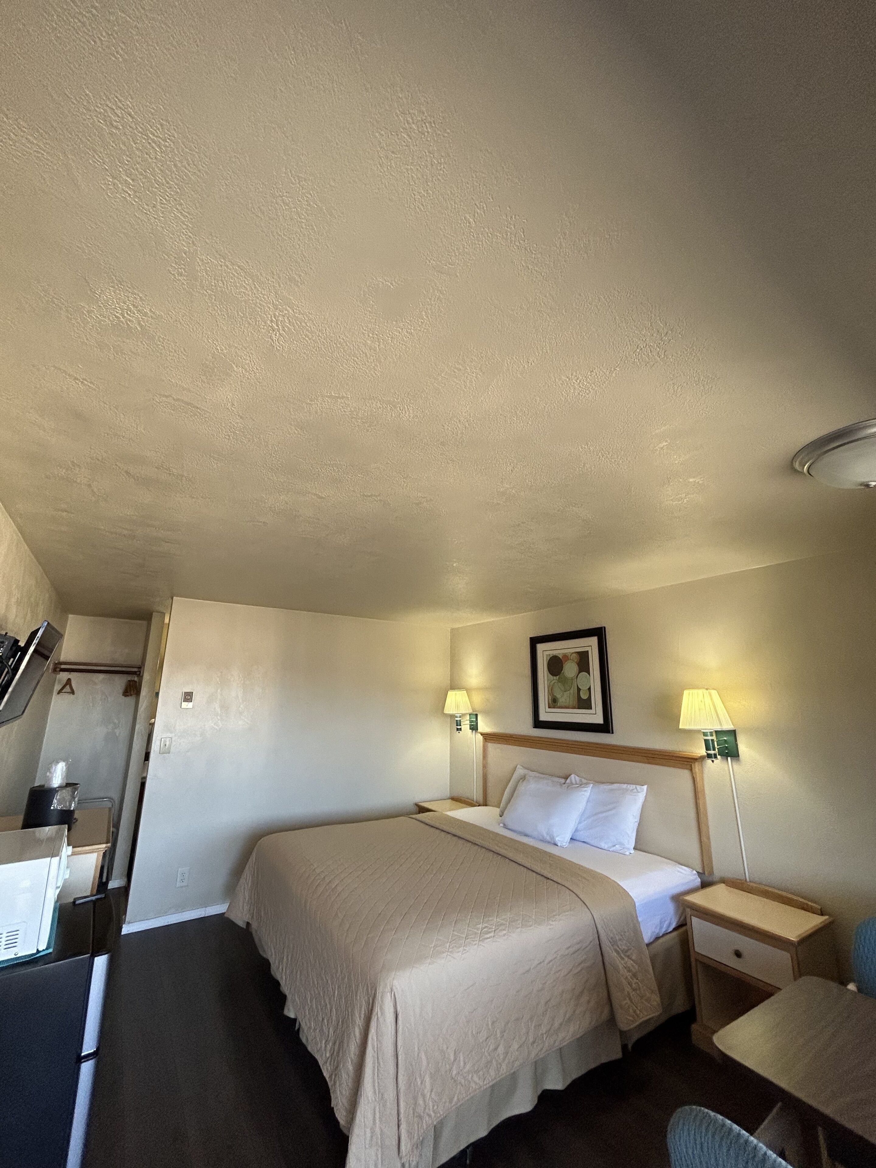 Une chambre d’hôtel comprenant un lit, des tables de chevet, un bureau et une chaise.