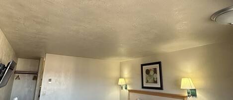 Una habitación de hotel con cama, mesitas de noche, escritorio y una silla.