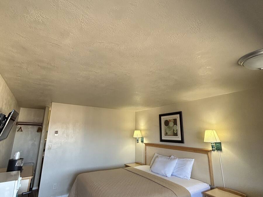 Une chambre d’hôtel comprenant un lit, des tables de chevet, un bureau et une chaise.