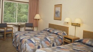 A hotel room with two beds, a desk, a chair, and a window with curtains. - Aspen Inn (Grand Marais)