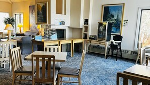 Un vaste espace de vie agrémenté d’une grande moquette bleue, de meubles en bois et d’une cheminée.