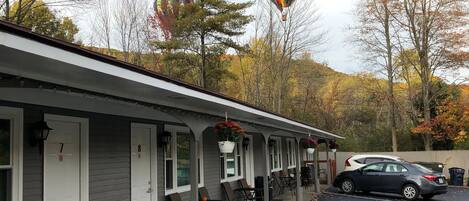 A motel with numbered rooms, outdoor seating, and a parking lot.