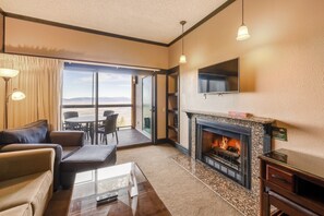 Una sala de estar moderna con chimenea, un sofá, una mesa de centro y un televisor montado en la pared.