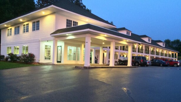 A two-story motel with a covered front porch and a parking lot. - Hurricane Inn (Waynesboro)