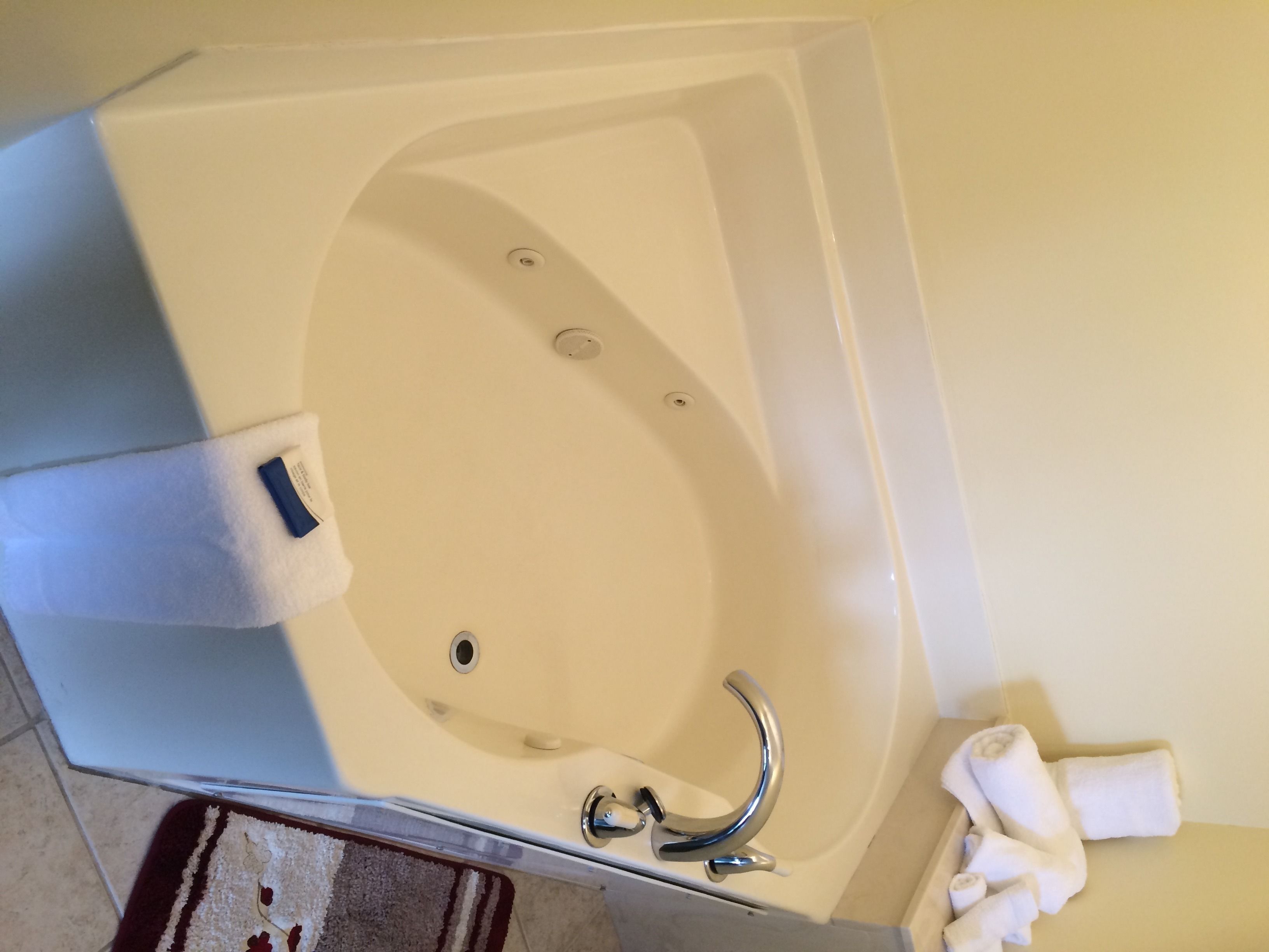A modern bathroom with a freestanding bathtub, a handheld showerhead, and a towel rack.