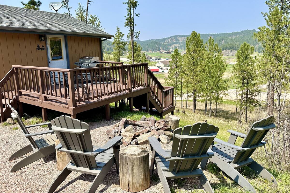 Une cabane dotée d’une terrasse, de meubles de jardin et offrant une vue sur le paysage environnant.