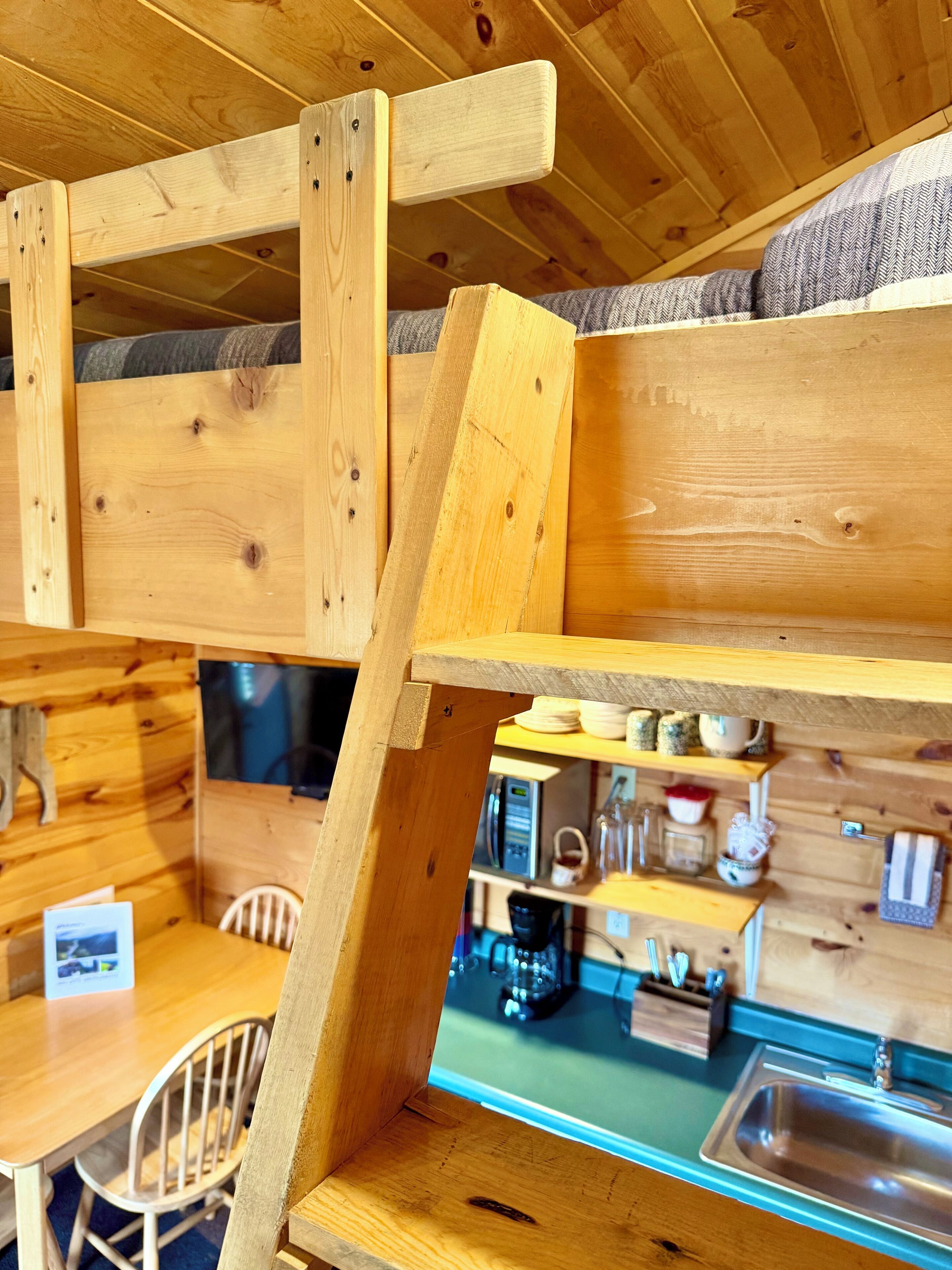 Un interior de madera con una zona de cocina, que incluye un fregadero y diversos utensilios.