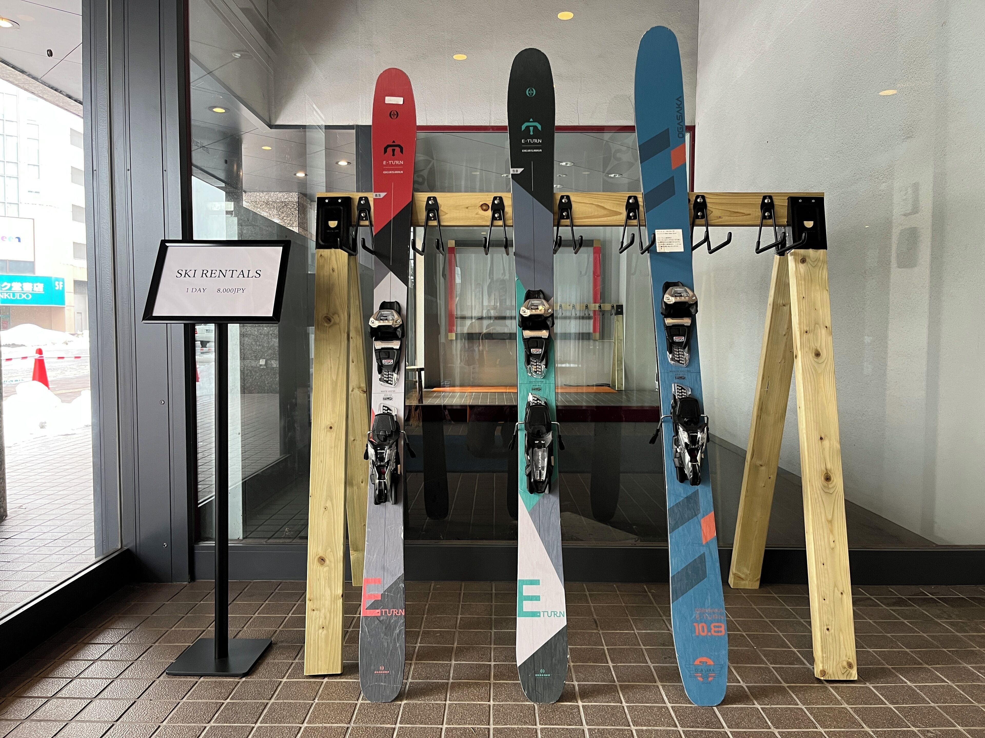 Un local de alquiler de esquíes con varias tablas de esquí exhibidas sobre soportes de madera.