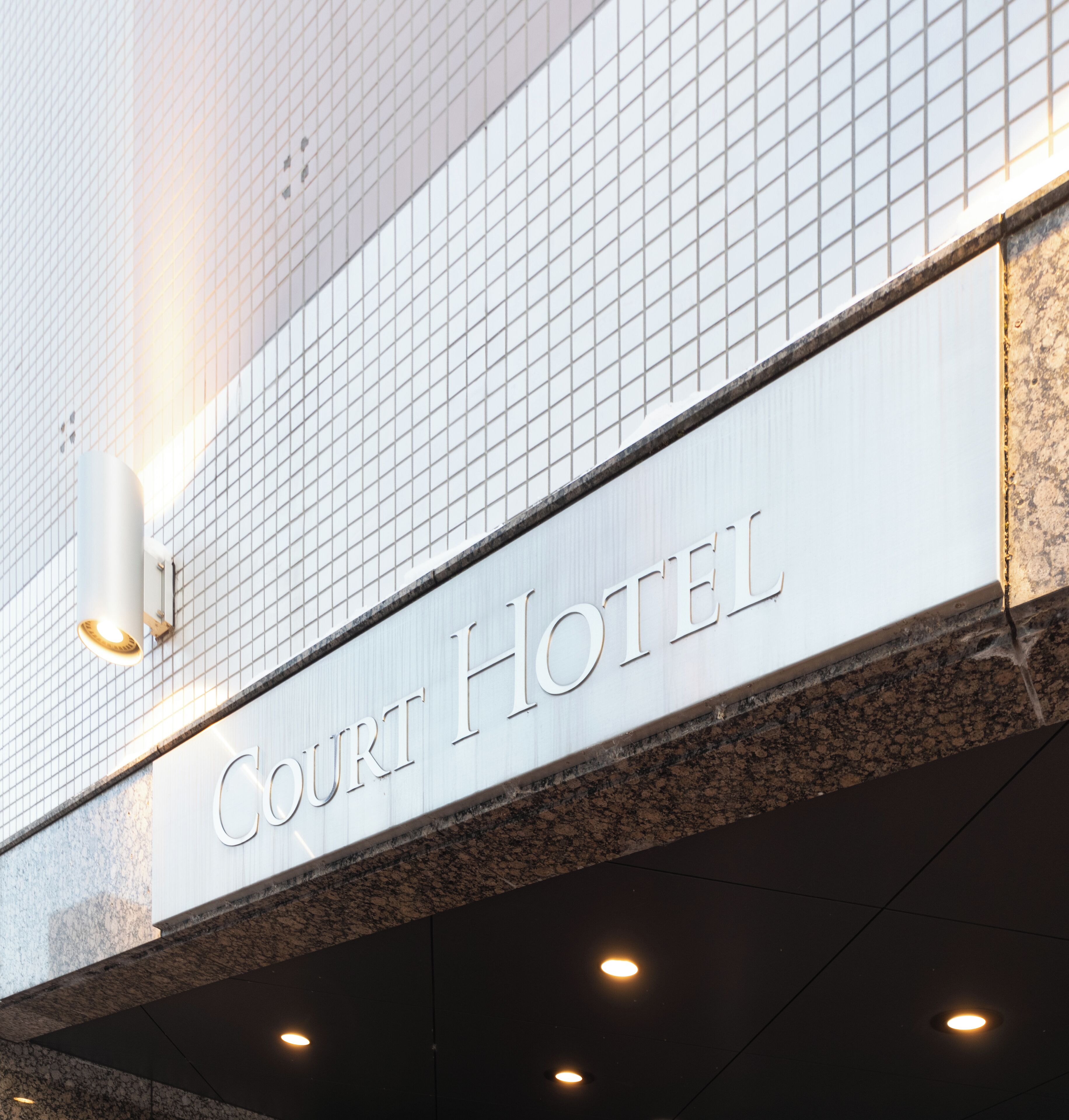 Een bord voor Hotel Court, met een modern ontwerp en een betegelde gevel.