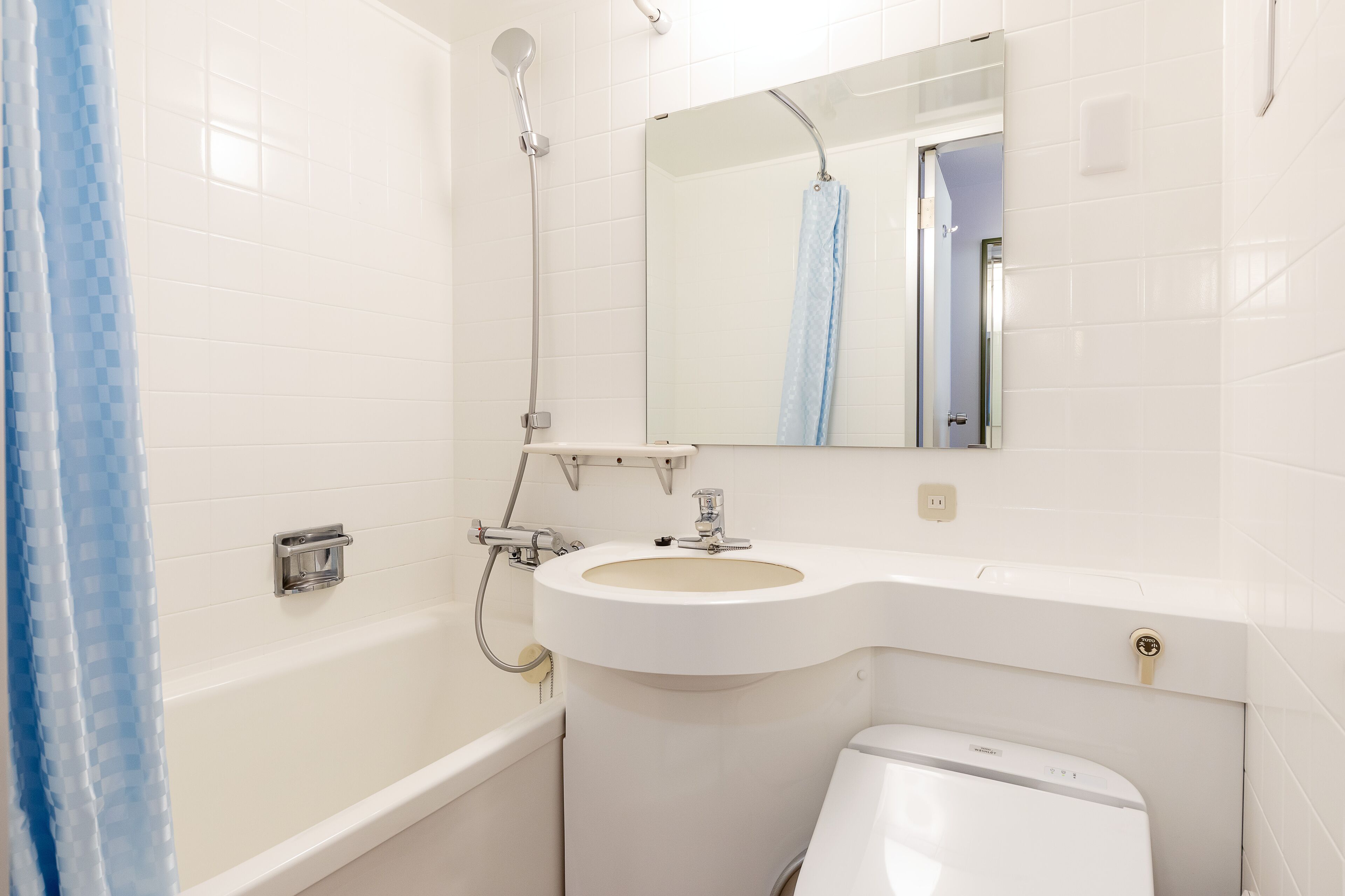 A bathroom with a bathtub, a sink, a toilet, and a shower curtain.