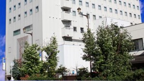 Een hotel met meerdere verdiepingen, een witte gevel en balkons.