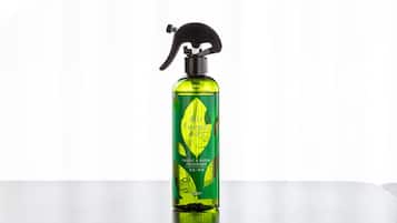 A bottle of air freshener on a reflective surface.