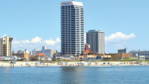 Une vue urbaine d’une ville côtière, avec un grand immeuble imposant portant l’inscription « Atlantic Palace ».