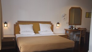 A hotel room with a bed, bedside tables, a desk, and a chair. - Kinabalu Pine Resorts (Ranau)