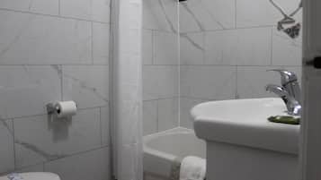 A bathroom with a toilet, a bathtub, and a sink.